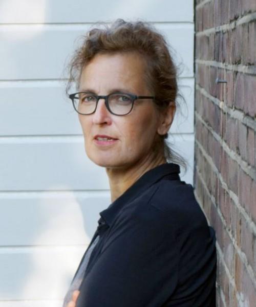 Annejan Mieras leunt tegen stenen muur
