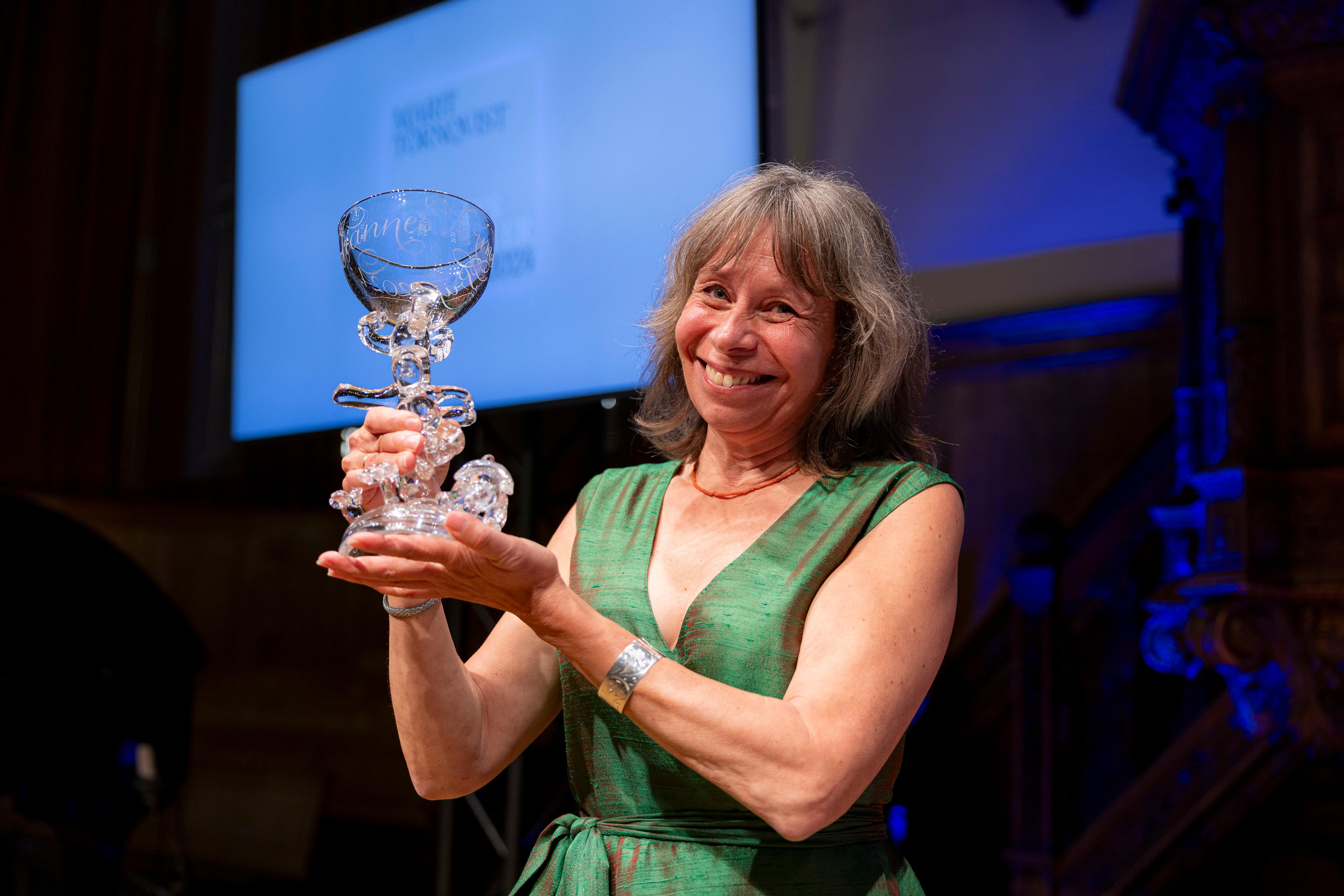 Lachende Marit Törnqvist met prijs in haar handen