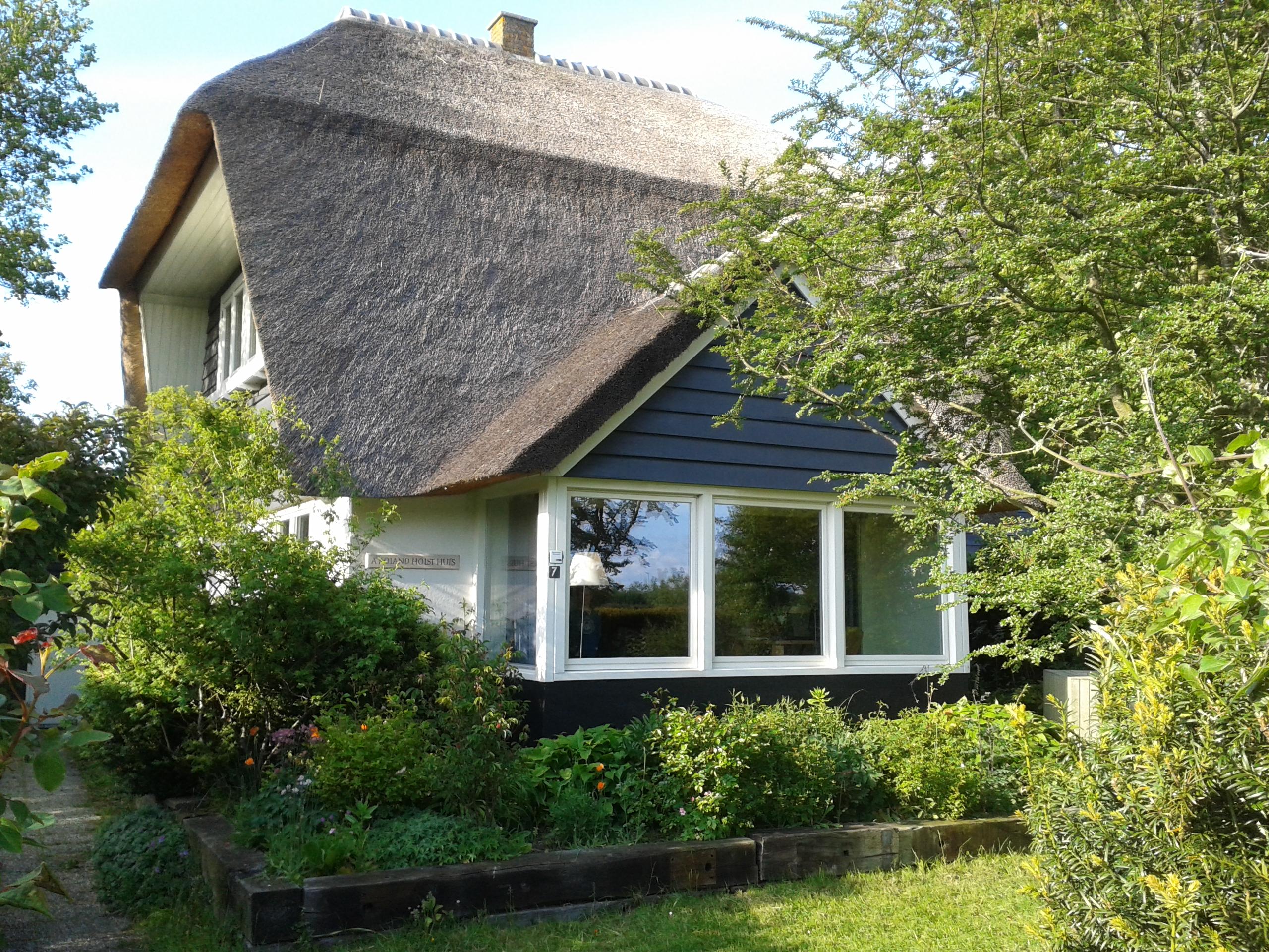 Huis met strooien dak tussen de bomen
